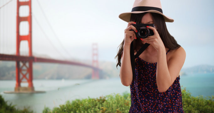 Close up of young tourist using camera by Golden Gate bridge in San Francisco