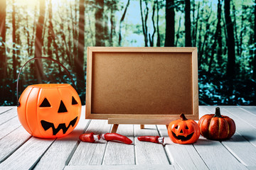 Halloween background. Spooky pumpkin, chalkboard on wooden floor with moon and dark forest....