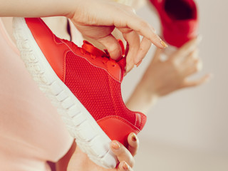 Happy woman presenting sportswear trainers shoes