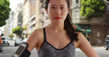 Close up of millennial female runner standing on urban street in San Francisco