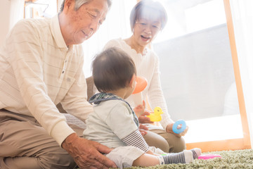 Obraz premium 赤ちゃんのお世話をするシニア夫婦