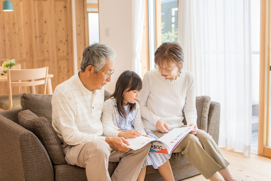 孫娘と絵本を読むシニア夫婦