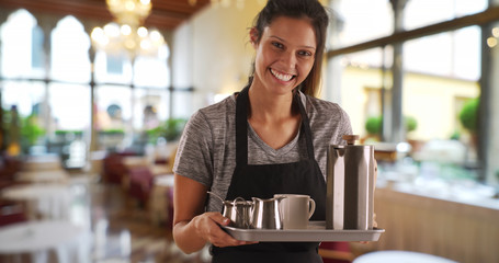 Pretty waitress in restaurant carrying tray with coffee beverages - obrazy, fototapety, plakaty