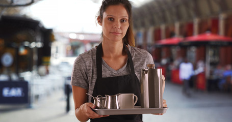 Tired waitress holding tray with coffee and tea on long shift