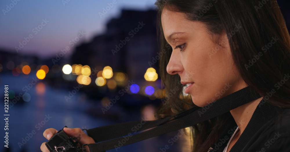 Wall mural tourist woman in italy takes evening picture by grand canal in historic city