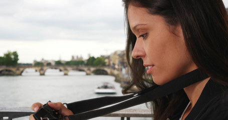 Obraz premium Young travel photographer in Paris taking picture while on bridge over the Seine