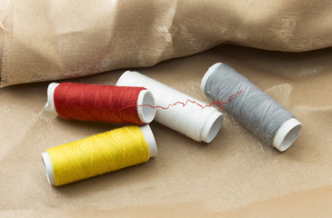 Several bobbins on a background of brown cloth