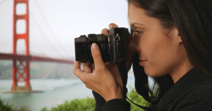 Closeup of tourist woman taking picture with dslr camera near Golden Gate Bridge