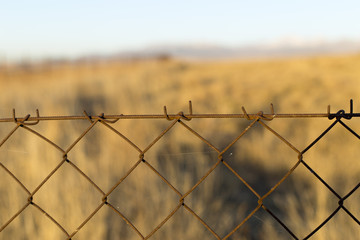 metal fence in the field at sunset