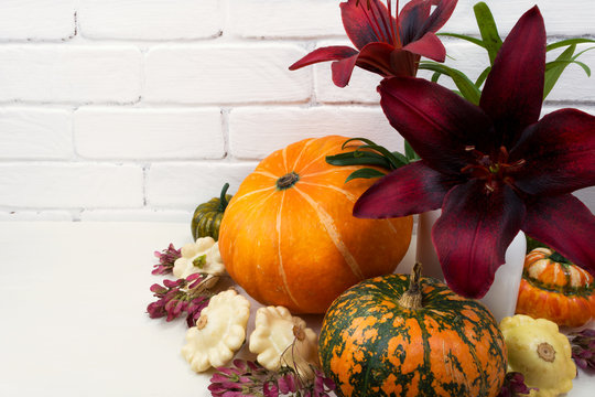 Fall table centerpiece with red lily and pumpkins