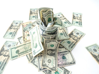 A closeup photograph of United States cash or paper bills overflowing out of a glass mason savings...