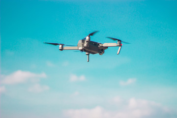 Fototapeta na wymiar Flying quadrocopter in a blue sky making movie. Photo and video.