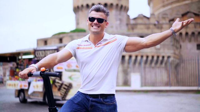 happy smiling tourist pleased to ride on the segway stands on the background of a historic building in the heart of Rome