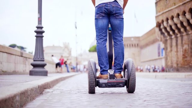 Riding segway in the street of city. Driving a personal transporter while visiting city. Slow motion 100fps