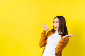 Asian girl is surprised she is excited.Yellow background studio - obrazy, fototapety, plakaty