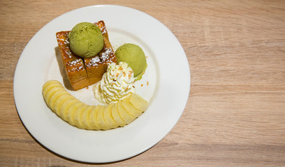 honey toast with vanilla ice cream and whiping cream topped with chocolate sauce on white dish. sweets bread and dessert. high calories from sugar. image for background, wallpaper and copy space.