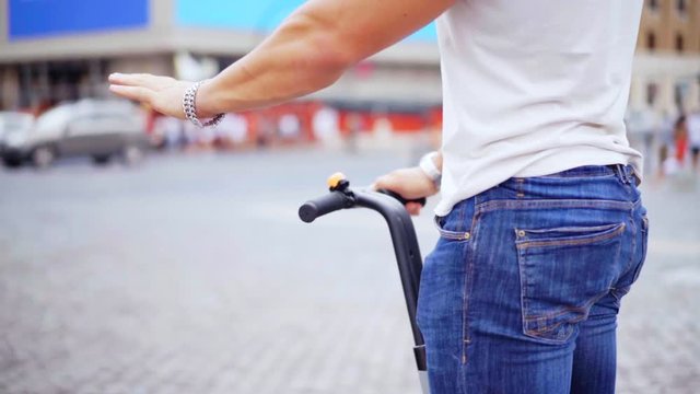 Close-up of a man's hand that holds behind the segways and slowly rides.