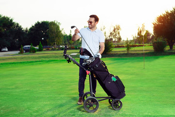 Young man golfer taking out the golf club from a bag - Powered by Adobe