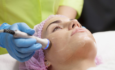 Obraz na płótnie Canvas Hardware cosmetology. Closeup picture of happy young woman getting rf lifting procedure in a beauty parlour. Radio lifting.