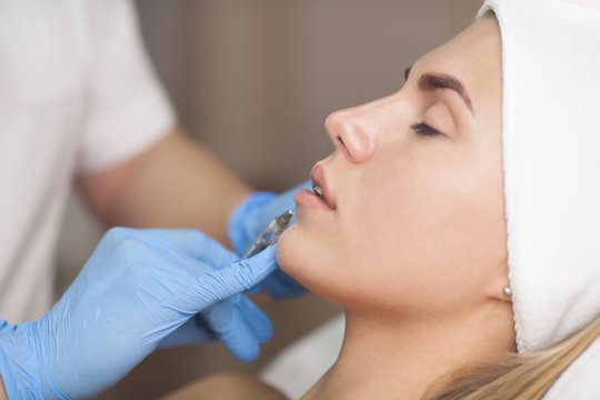 The cosmetologist makes injections of botulinum toxin in the lips of the patient. Cosmetology skin care.