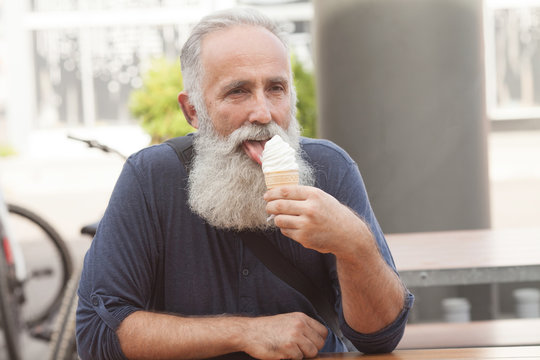 Happy Senior man eating ice cream cone
