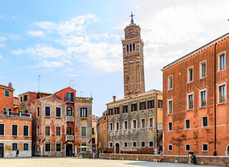 Old square with a leaning bell tower of the Chiesa di Santo Stefano church in the background in Venice Italy