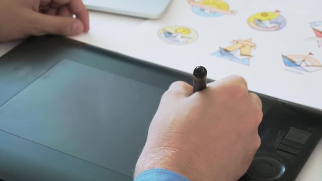 Graphic designer using graphics tablet while working on a logo design
