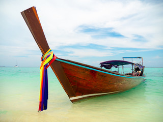 Traditional Long boat  with colorful ribbons on Phi Phi Island near Phuket in Thailand on turquoise...