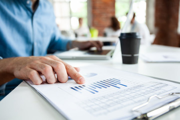 Portrait of young man sitting at his desk in the office