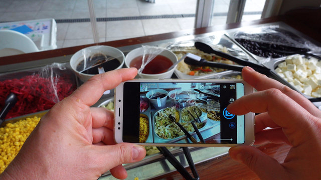 Taking photo of food with smartphone , mobile blogger. Social network concept.