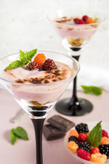 Milk dessert with berries in tall glasses. Selective focus.