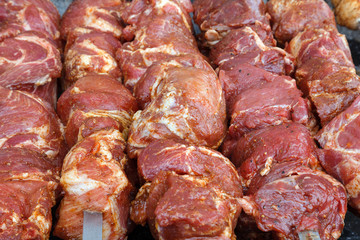 Kebab roasting on the grill on metal skewers. BBQ party.