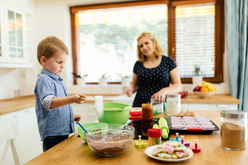 Obraz na płótnie Canvas Child helping mother make muffins