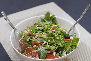 Homemade vegetarian salad with tomatoes, onions, olives, arugula, brynza and olive oil. Recipe with...