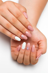gently pink manicure with white pearly rub on long oval nails with crystals, rhombuses on a white background
