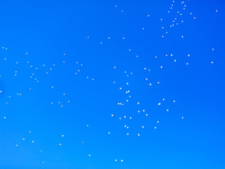 White balls flying in the blue sky