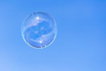 Soap bubbles in flight against the blue sky