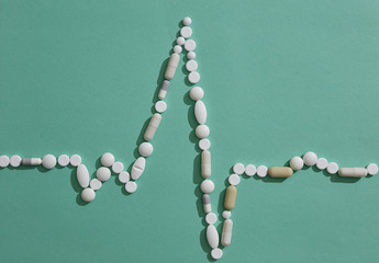 Pills forming pulse trace on green background