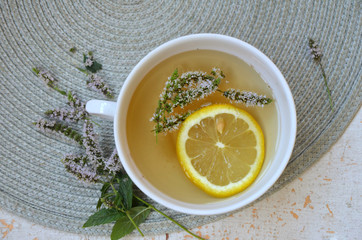  herbal tea with lemon and mint in a white mug