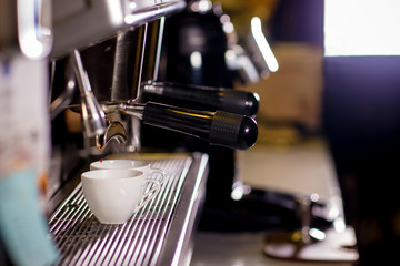 Barista make coffee espresso shot by streaming machine in coffee cafeteria bar. Brewing Process concept. coffee blending process. image for background, wallpaper,decoration and copy space.
