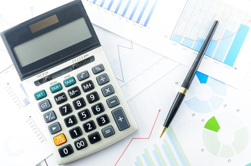 Calculator and Pen with Business Graphs finance document.	