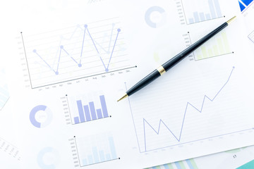 Close up a Pen on Business Graphs finance document.	