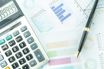 Calculator and Pen with Business Graphs finance document.	