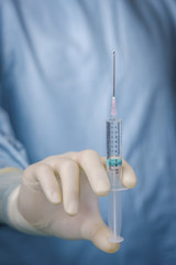 Close up surgeon holding syringe