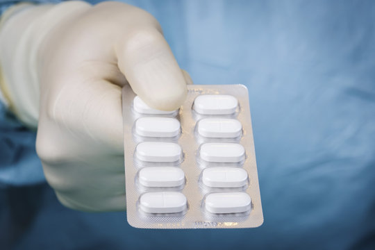 Close up scientist holding blister pack of pills