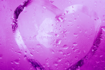 Hand draw heard and a lips print on the window wet glass