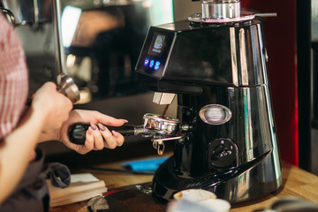 Barista using a coffee machine in cafe