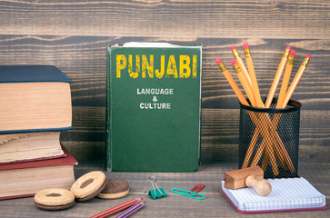 Punjabi language and culture concept. Book on a wooden background