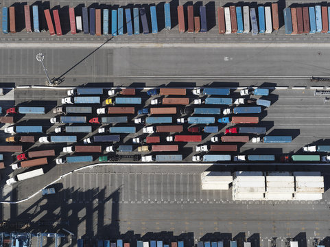 Aerial view semi trucks with containers in sunny shunting yard, Los Angeles, California, USA