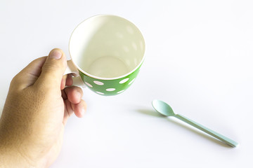 Hand hold green coffee cup with white dots separated from white background.